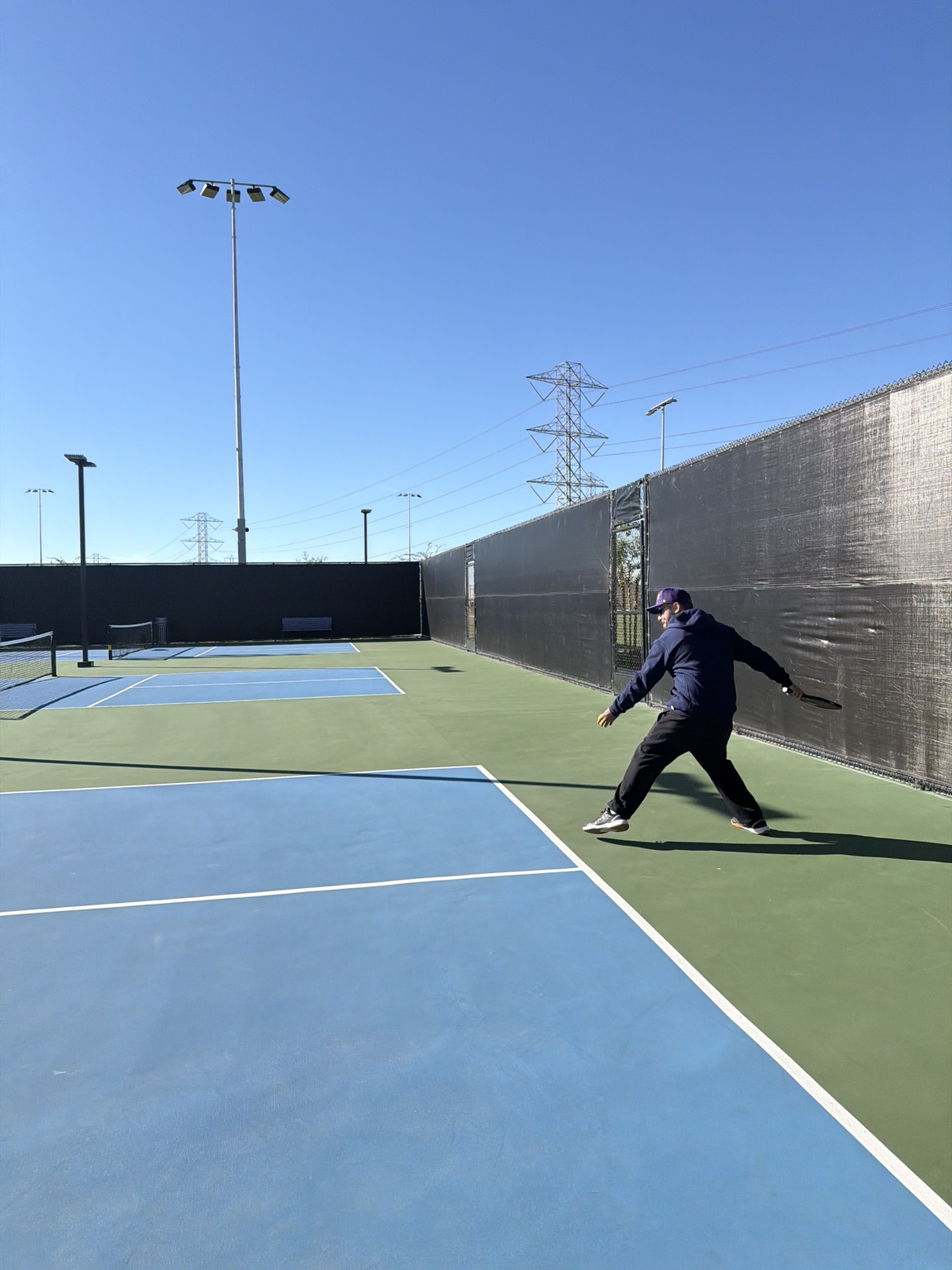 Sean practicing a shot on an outdoor pickleball court